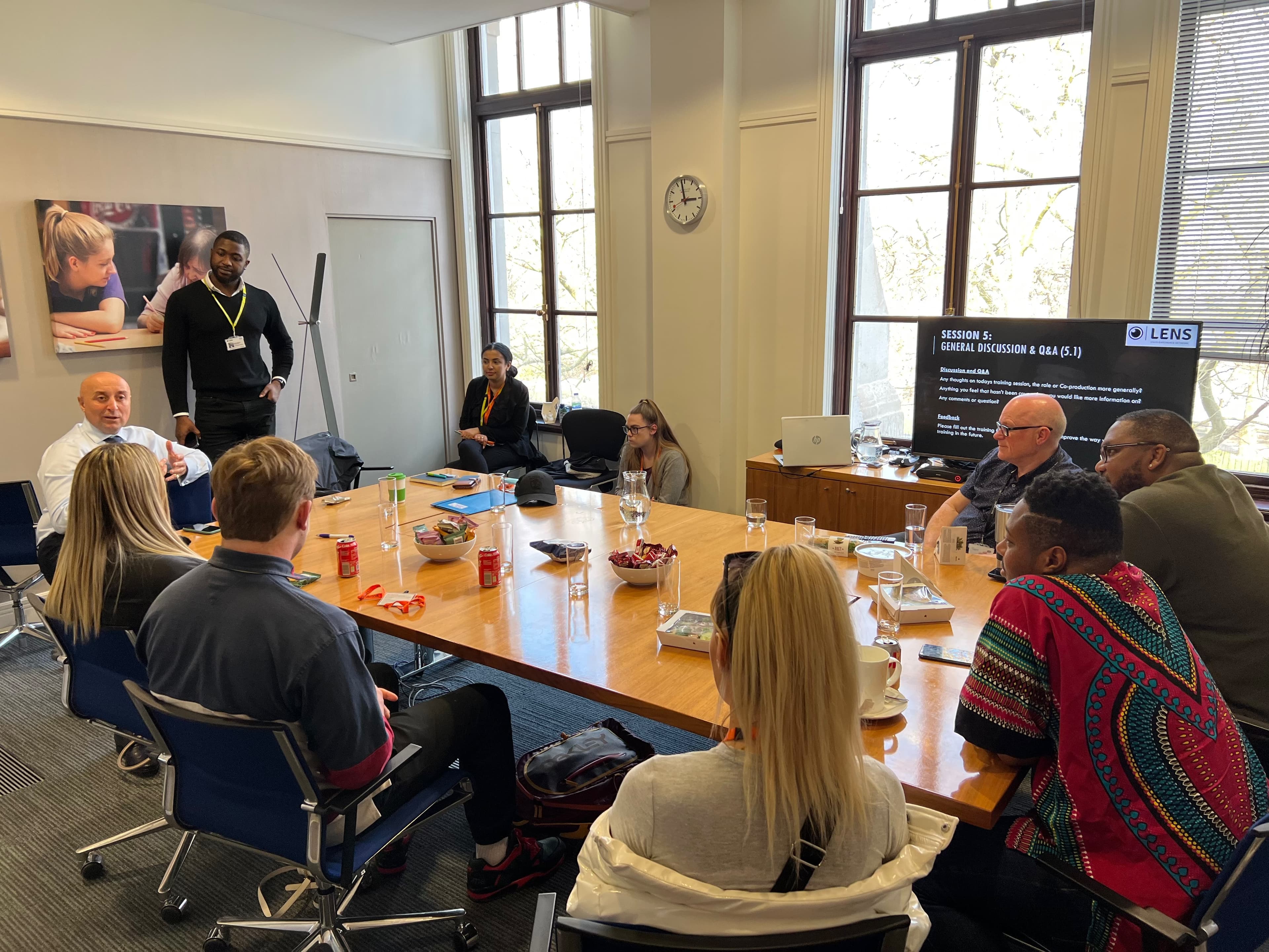 A group taking part in a LENs training discussion around a meeting table.